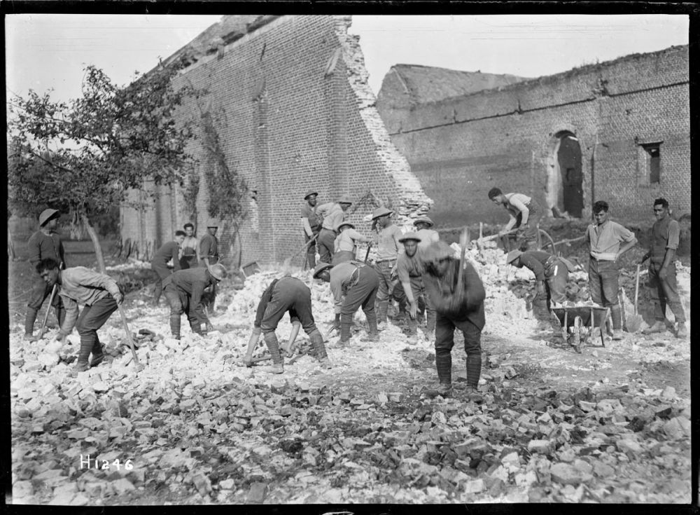 Men from the New Zealand Pioneer Battalion make a road through damaged buildings, France 1918.